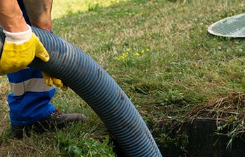 A specialist performing a septic tank inspection.