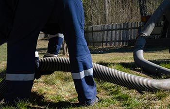 A specialist performing septic tank pumping.