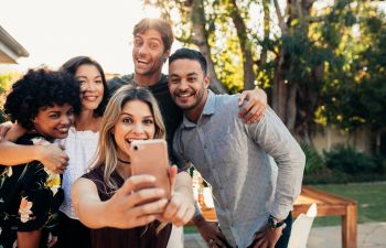 A group of friends taking selfie during a garden party.