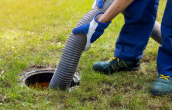 man pumping out house septic tank drain and sewage cleaning service